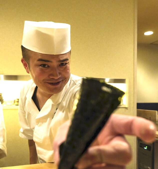 A Rinda sous chef brandishes a temaki roll. Picture: Ben Groundwater A Rinda sous chef brandishes a temaki roll. Picture: Ben Groundwater
