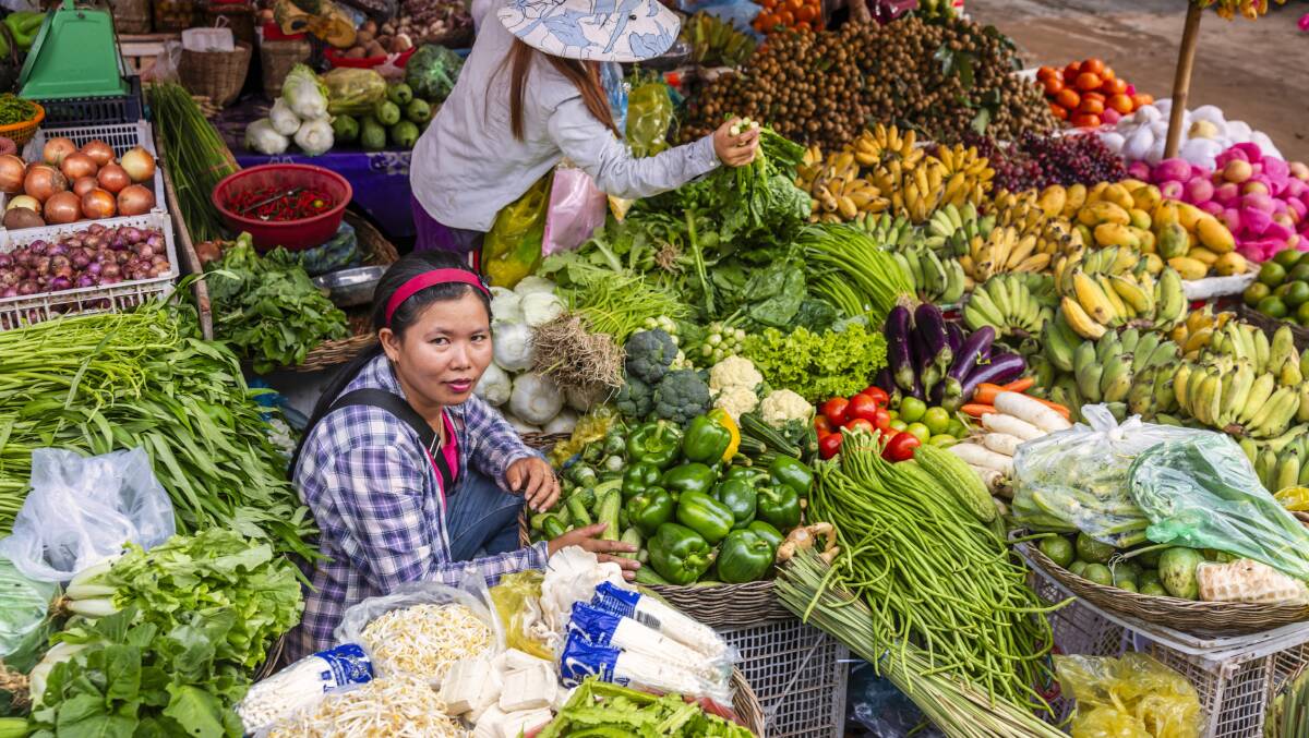 Cambodian women selling fresh fruits and vegetables on a local market in Siem Reap. Picture: Getty Images Cambodian women selling fresh fruits and vegetables on a local market in Siem Reap. Picture: Getty Images