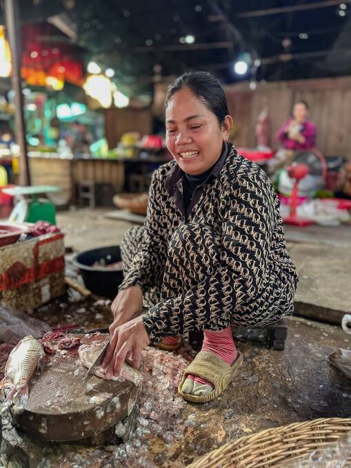 A woman descaling fish at Puok Market. Picture: Alex Mitcheson A woman descaling fish at Puok Market. Picture: Alex Mitcheson