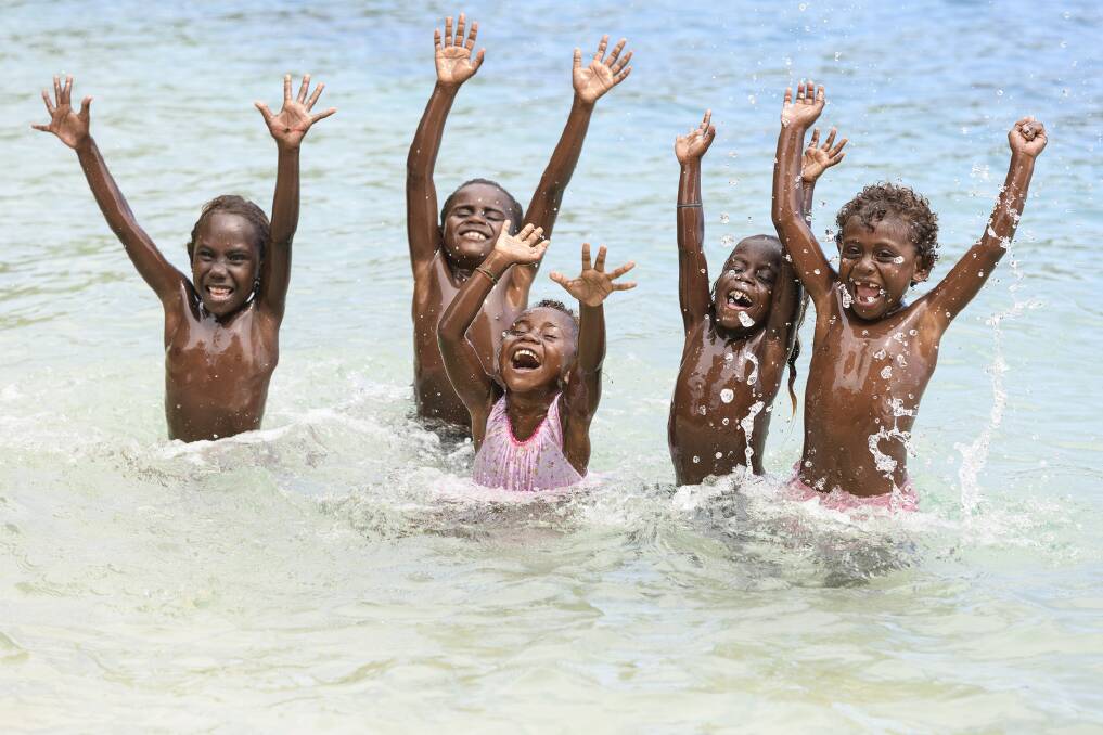 Small children swim in the tropical waters around Saeraghi. Picture: Chris Mclennan Small children swim in the tropical waters around Saeraghi. Picture: Chris Mclennan