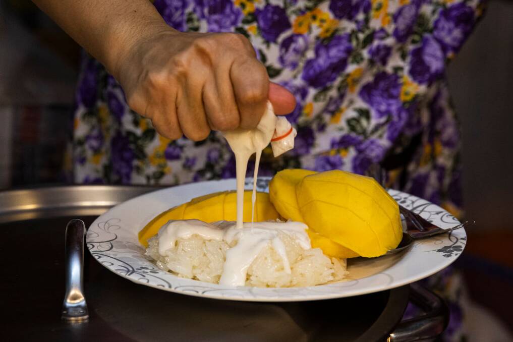 A floating market vendor prepares mango sticky rice. Picture: Getty Images