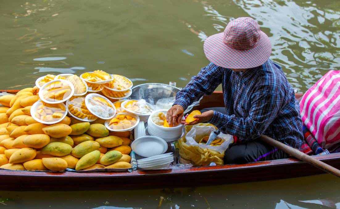 A floating market vendor prepares mango sticky rice. Picture: Shutterstock