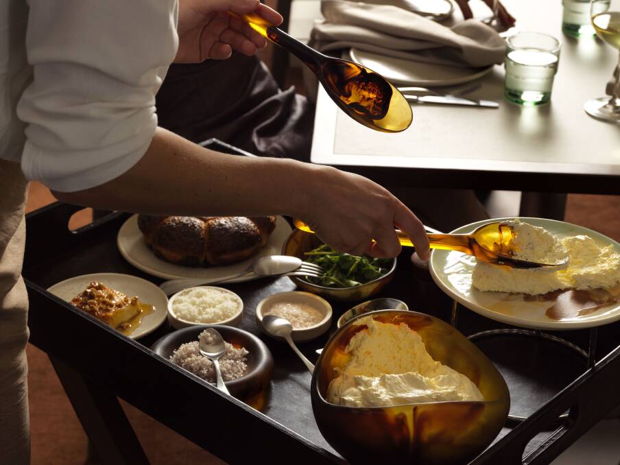 A waiter carries out the tableside bread and butter service at Tilda restaurant.
