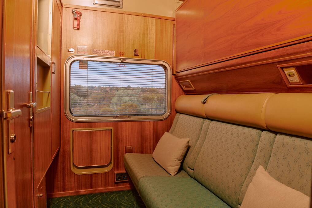 The Gold twin cabin featuring a picture window, three person-wide bench seat, and a drop-down top bunk.