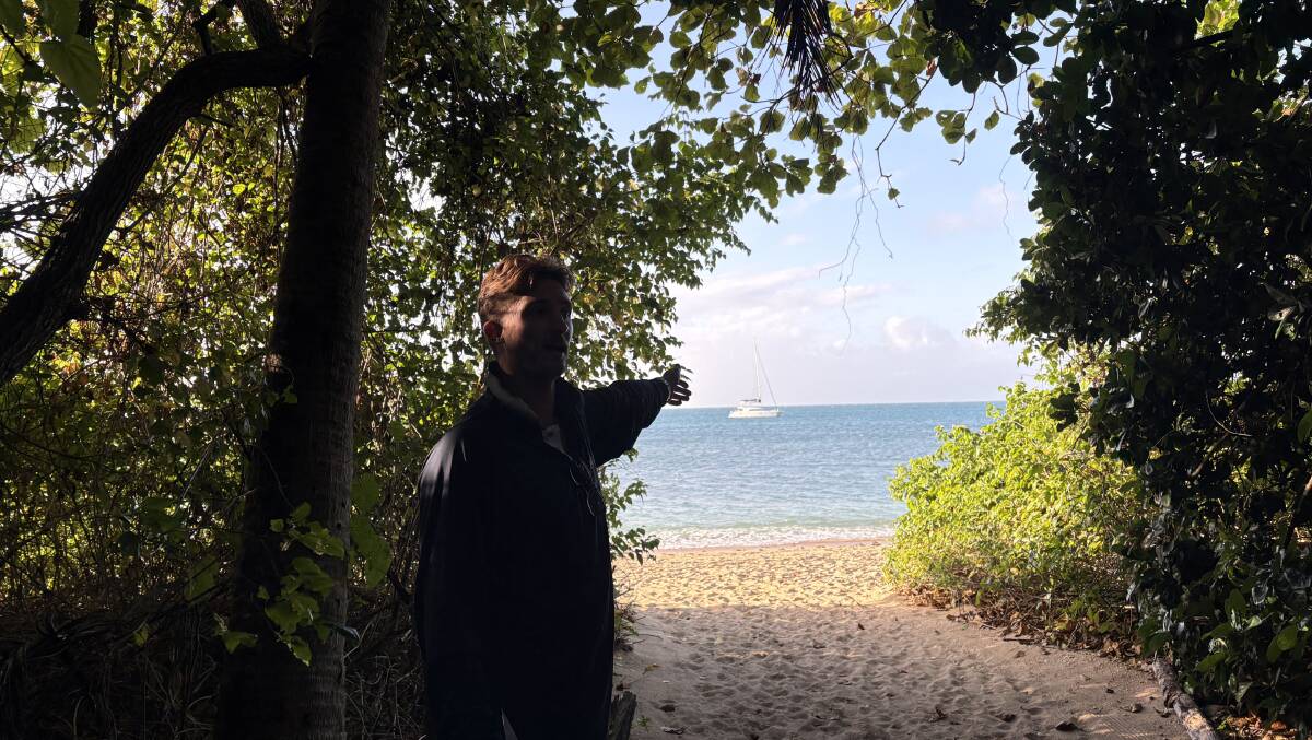 A natural opening in the greenery reveals a world-class catamaran anchored close to Coral Cay Island. Picture by Bageshri Savyasachi