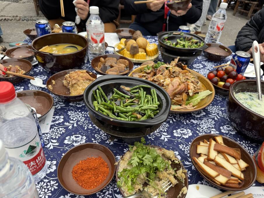 A traditional Miao lunch prepared in Shizhu county with beans, corn, cabbage, tofu, roast chicken, lamb, soup and fresh cherry tomatoes. Picture by Bageshri Savyasachi