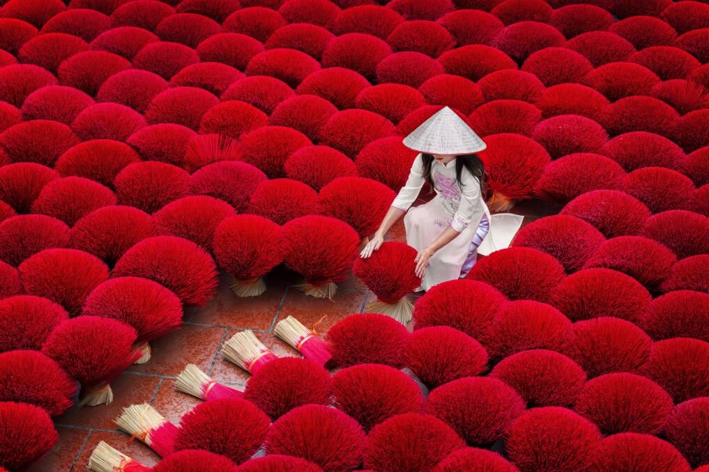 A woman drying incense sticks in Hanoi. Picture: Shutterstock 