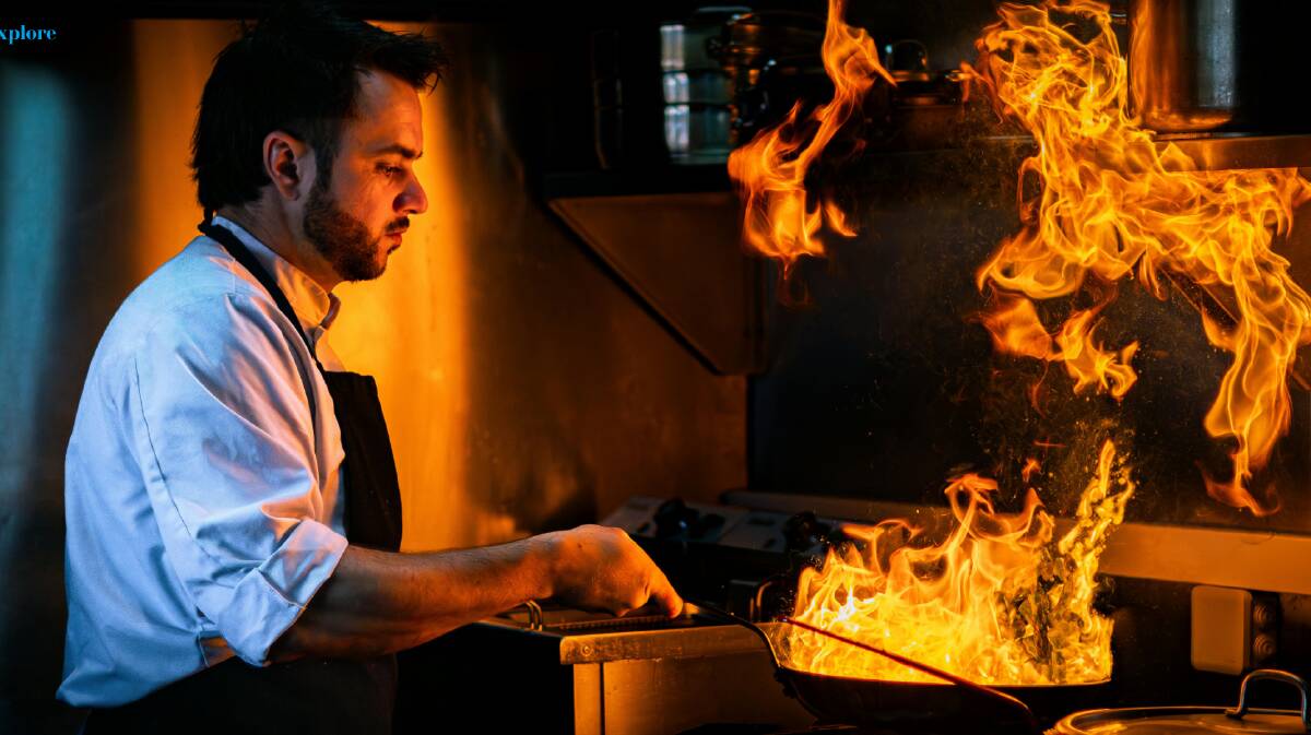A chef watches over flames in a hot pan. Picture Canva
