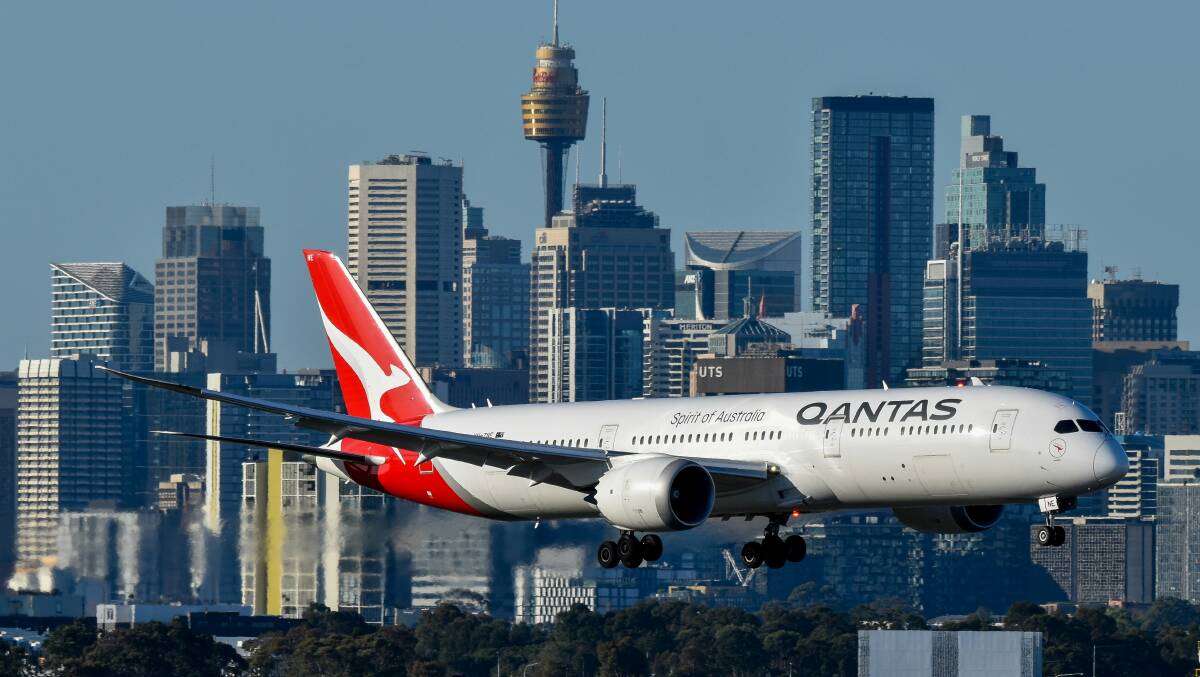 Qantas plane with Sydney skyline in the background. Picture David Syphers/Unsplash