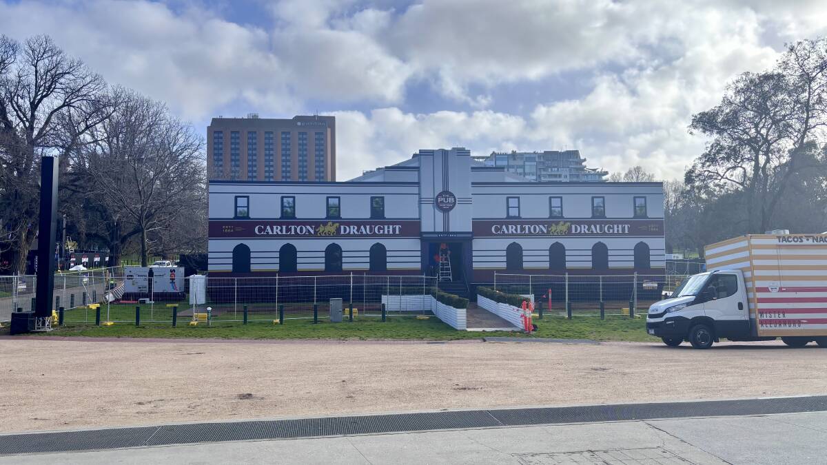 Organisers work quickly to erect a classic Australian pub at the MCG. Picture Anna Houlahan
