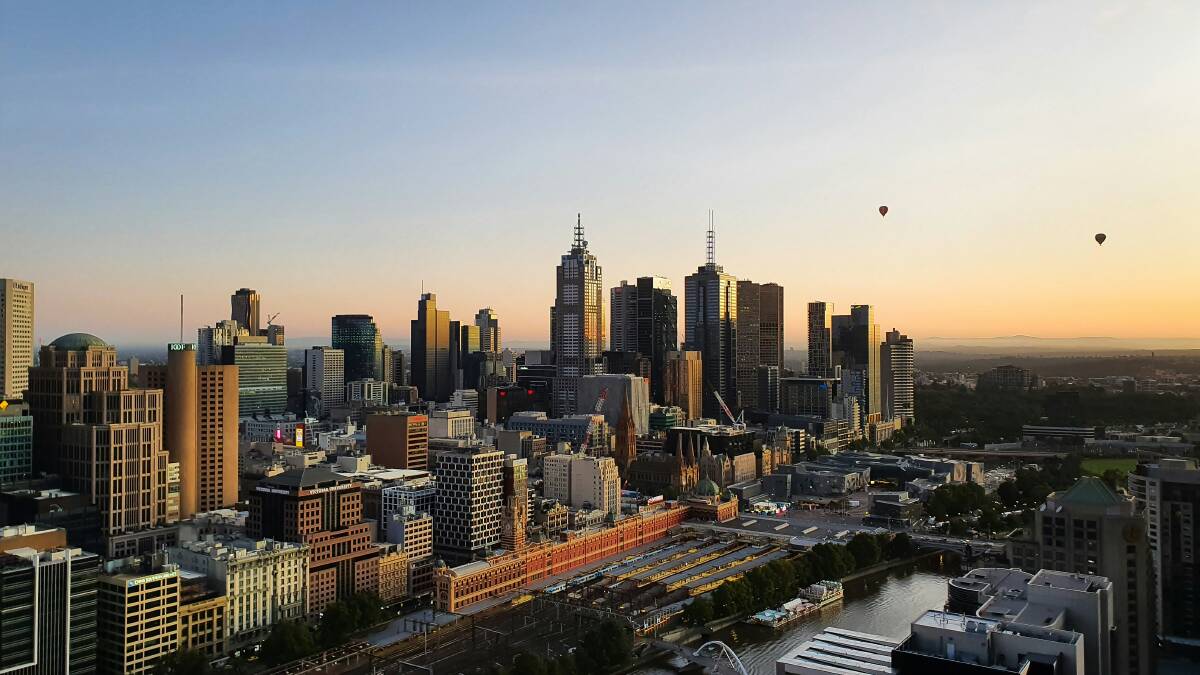 Hot air balloons rise over Melbourne's CBD in the early morning. Picture Unsplash/Urlaub Stracker