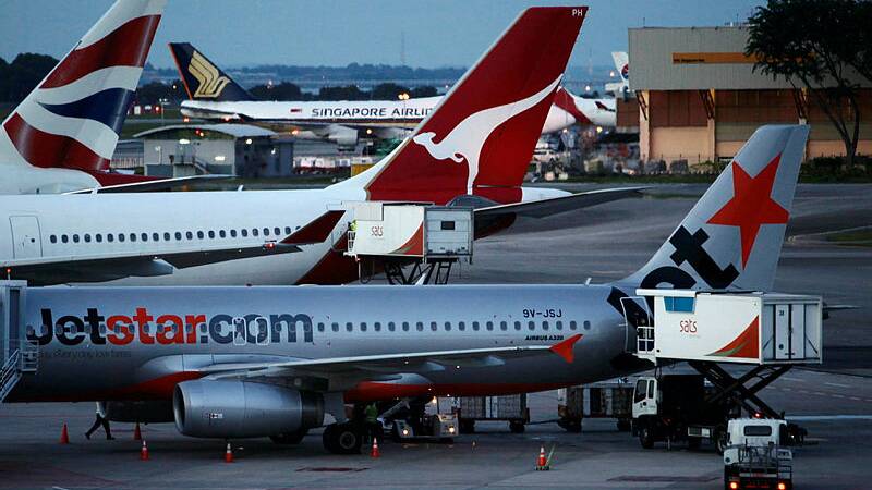 A Qantas Airbus A330-300 aircraft is parked between a Jetstar Airbus A320 (front) and a British Airways plane at Changi Airport in Singapore. Picture by REUTERS/Tim Chong