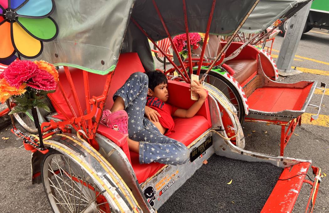 A young boy takes a rest in his dad's rickshaw in Penang. Picture: John Hanscombe A young boy takes a rest in his dad's rickshaw in Penang. Picture: John Hanscombe