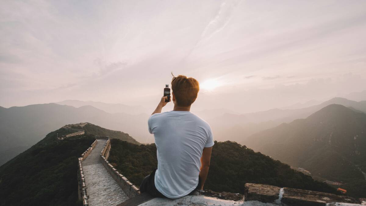 A tourist takes footage of the Great Wall of China. Picture by Road Trip with Raj/Unsplash