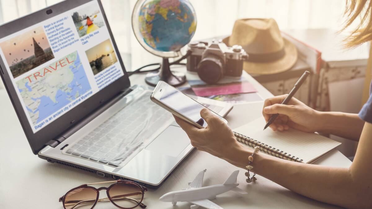 A woman calculates her travel costs. Picture by Shutterstock