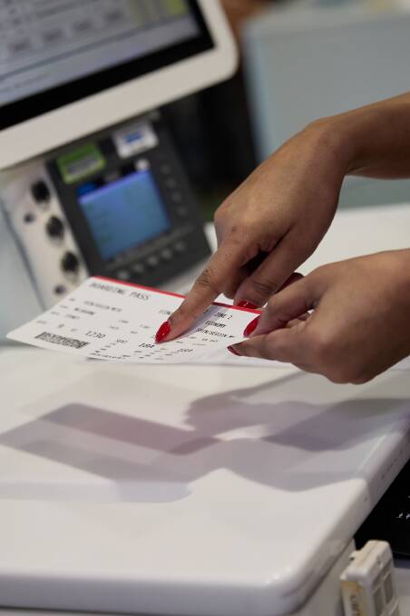 A staff member points to a pet-friendly seat number on a Virgin Australia boarding pass. Picture supplied A staff member points to a pet-friendly seat number on a Virgin Australia boarding pass. Picture supplied