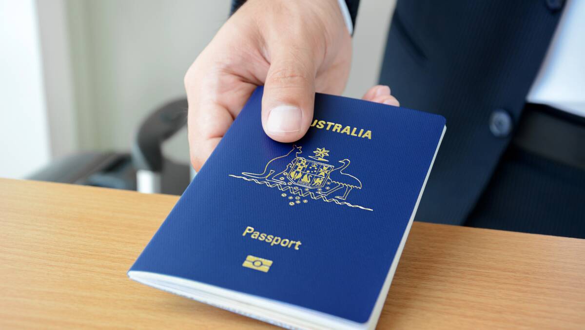 A traveller hands over an Australian passport. Picture: Shutterstock A traveller hands over an Australian passport. Picture: Shutterstock