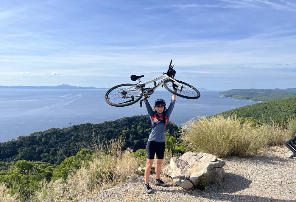 The writer celebrates, bike aloft. The writer celebrates, bike aloft.