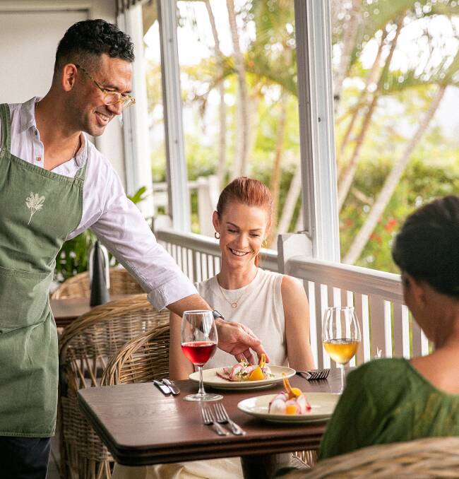 Waiter serving lunch to a couple on deck at Tweed River House in Murwillumbah.