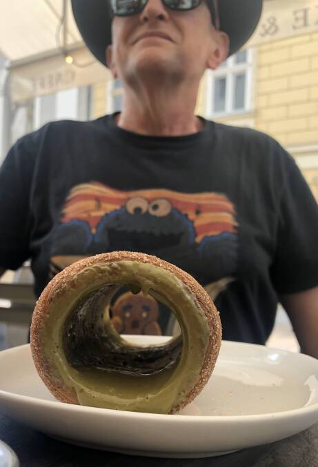 The writer gets ready to tuck into Budapest's favourite sweet treat: a freshly baked, delectably crispy-but-fluffy cinnamon chimney cake, this one drizzled with a pistachio filling. 
